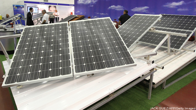 Visitors check solar panels at a stand p