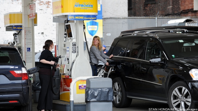 People pump gasoline at a Shell station