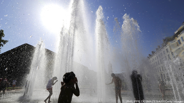 Children play in a fountain to refresh o