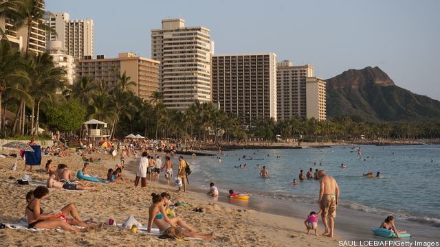 Tourists swim, sunbathe and relax along