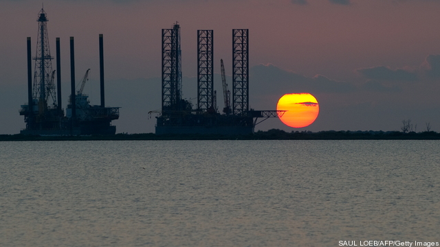 The sun sets behind two under constructi