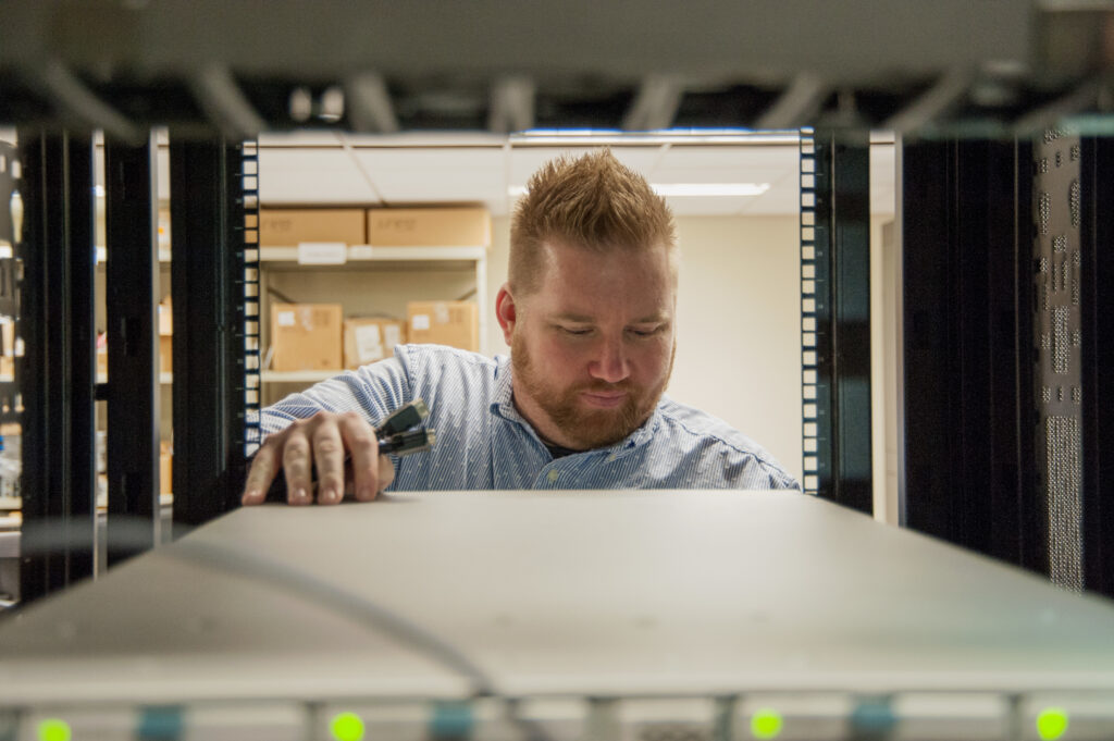 A Man inspects a server at Naval Information Warfare Systems Command