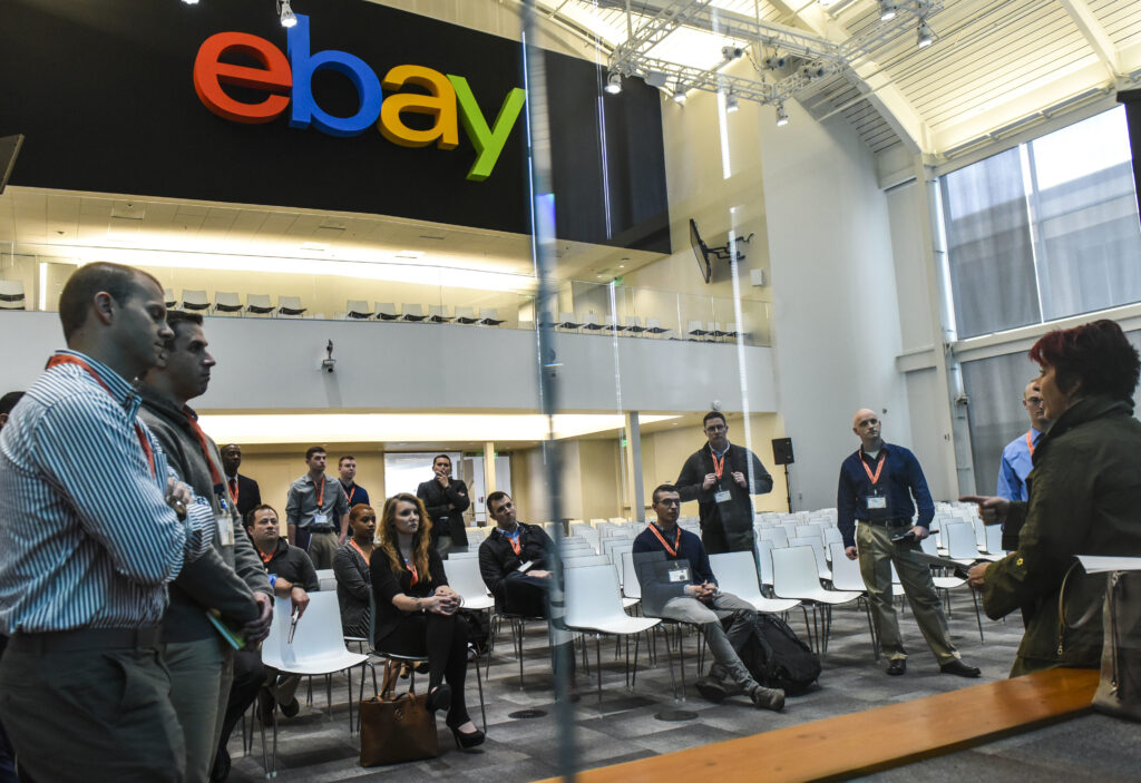 Military members wearing lanyards stand in an ebay lobby.