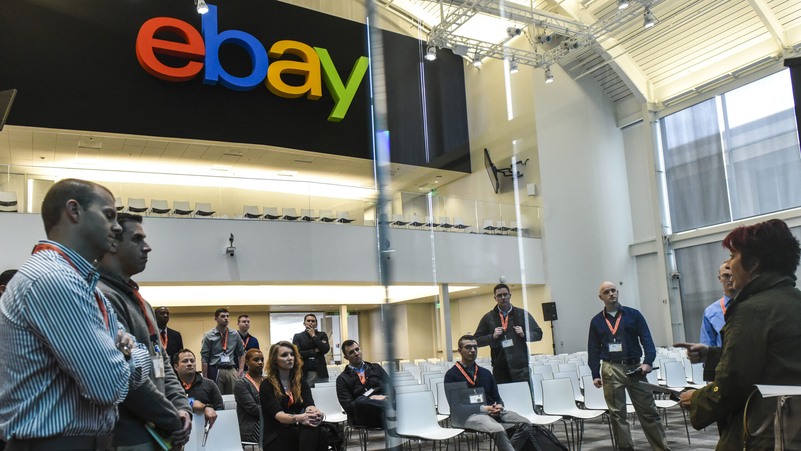 Military members wearing lanyards stand in an ebay lobby.