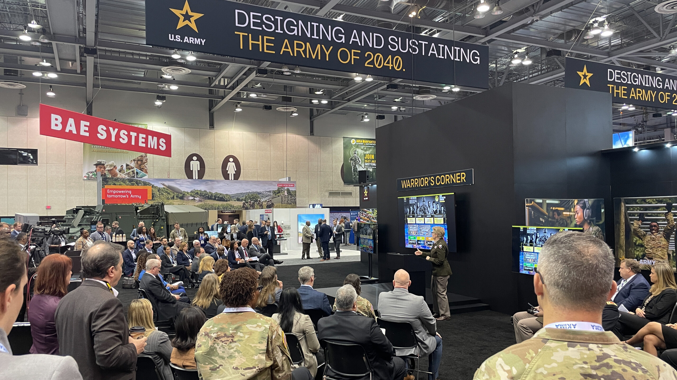 Brigadier General Christine A. Beeler speaks to a large group at the Warriors Corner regarding Army Contracting at AUSA Global Day 2.