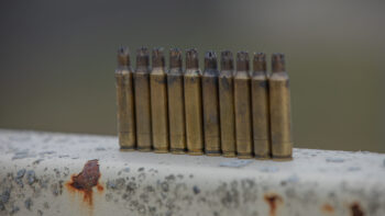 A row of blank ammunition shells stand on a rail.